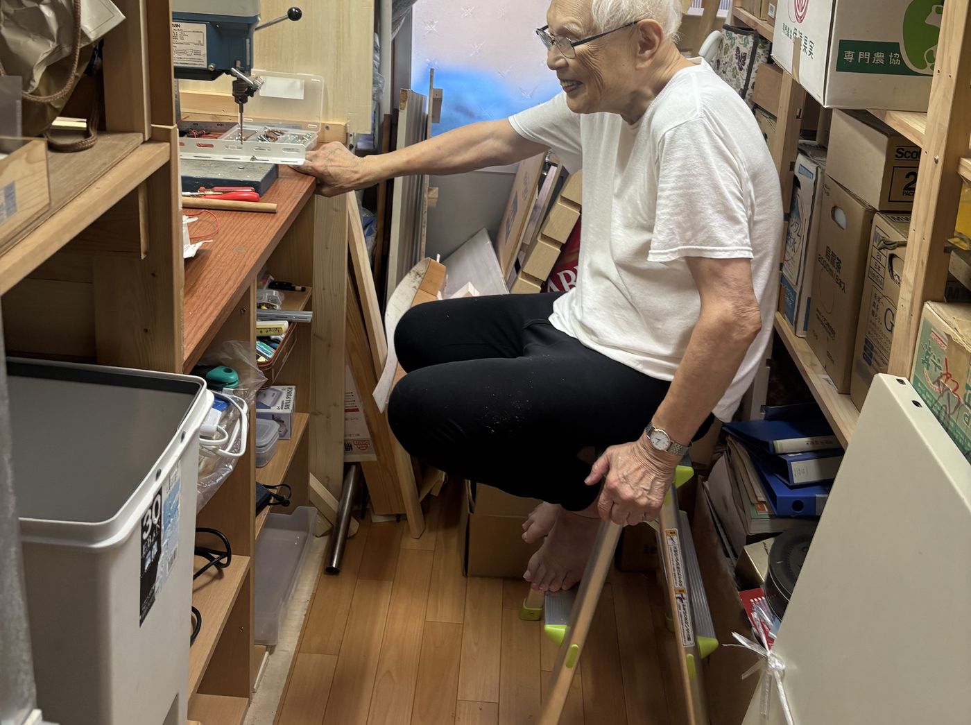 部品や工具が並ぶ作業部屋で装置に向かう代表